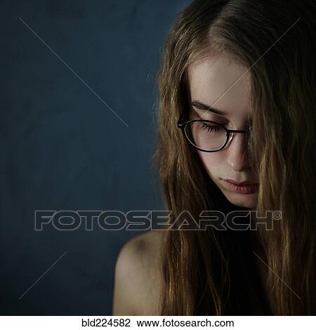 Stock Image - Caucasian teenage girl looking down. Fotosearch