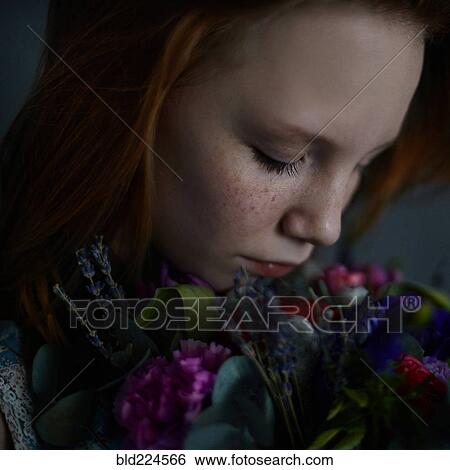 Stock Photograph - Caucasian teenage girl smelling flowers. Fotosearch