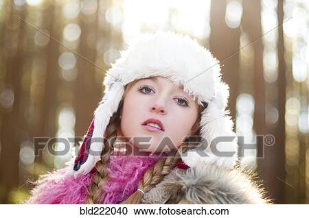 Stock Image - Caucasian teenage girl wearing fuzzy hat outdoors. Fotosearch