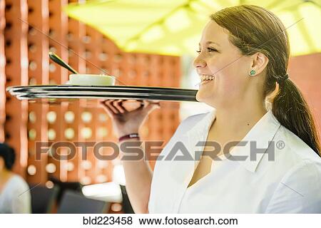 Caucasian waitress carrying tray in restaurant View Large Photo Image Stock Photo - Caucasian waitress carrying tray in restaurant. Fotosearch
