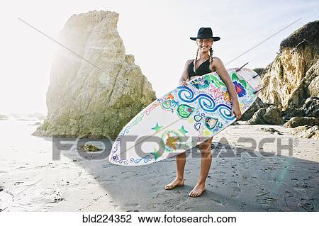 Caucasian woman carrying surfboard at beach View Large Photo Image Stock Image - Caucasian woman carrying surfboard at beach. Fotosearch