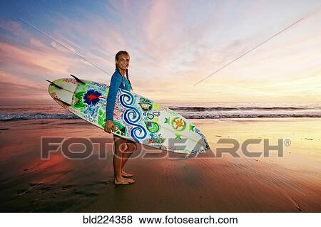 Caucasian woman carrying surfboard at beach View Large Photo Image Stock Photo - Caucasian woman carrying surfboard at beach. Fotosearch