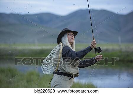 Caucasian woman casting fishing line in remote lake View Large Photo Image Stock Photo - Caucasian woman casting fishing line in remote lake. Fotosearch