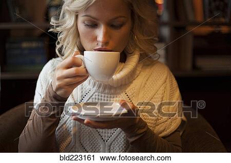 Stock Image - Caucasian woman drinking cup of coffee. Fotosearch