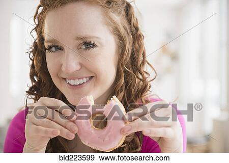 Caucasian woman eating donut View Large Photo Image Stock Photo - Caucasian woman eating donut. Fotosearch