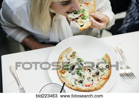 Caucasian woman eating slice of pizza in restaurant View Large Photo Image Stock Image - Caucasian woman eating slice of pizza in restaurant. Fotosearch