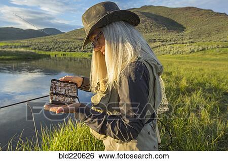 Caucasian woman examining fishing tackle near remote lake View Large Photo Image Stock Photograph - Caucasian woman examining fishing tackle near remote lake. Fotosearch
