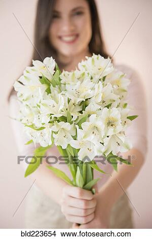 Picture - Caucasian woman holding bouquet of white flowers. Fotosearch