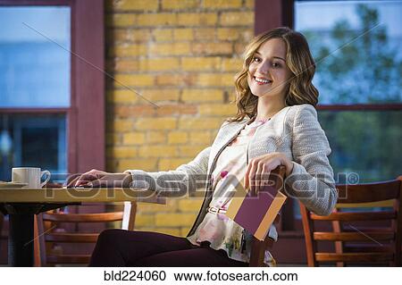Stock Image - Caucasian woman holding menu in restaurant. Fotosearch