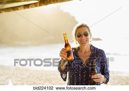 Caucasian woman holding two bottles of beer View Large Photo Image Stock Image - Caucasian woman holding two bottles of beer. Fotosearch