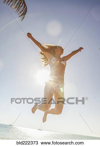 Caucasian woman in bikini jumping for joy View Large Photo Image Stock Image - Caucasian woman in bikini jumping for joy. Fotosearch