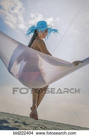 Picture - Caucasian woman in hammock at beach. Fotosearch