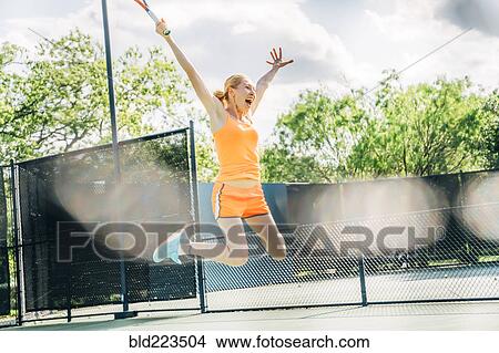 Caucasian woman jumping for joy on tennis court View Large Photo Image Picture - Caucasian woman jumping for joy on tennis court. Fotosearch