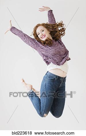 Stock Photo - Caucasian woman jumping for joy. Fotosearch