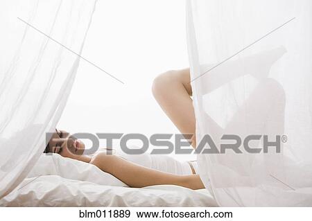 Stock Photo - Caucasian woman laying in bed. Fotosearch