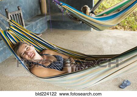 Stock Image - Caucasian woman laying in hammock. Fotosearch