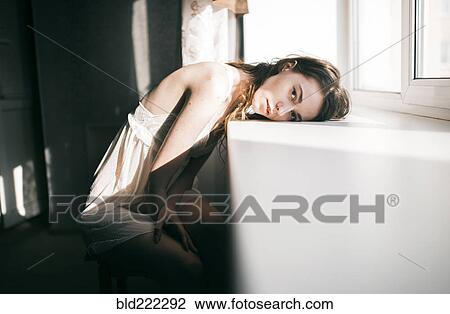 Caucasian woman leaning on windowsill View Large Photo Image Stock Image - Caucasian woman leaning on windowsill. Fotosearch