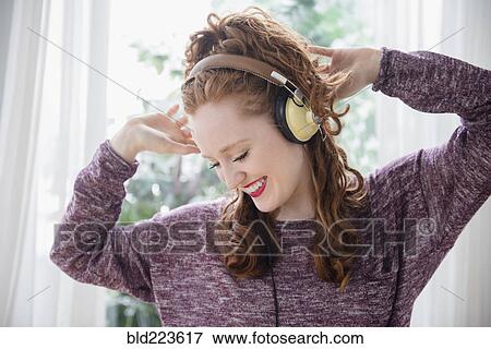 Caucasian woman listening to headphones and dancing View Large Photo Image Stock Photo - Caucasian woman listening to headphones and dancing. Fotosearch