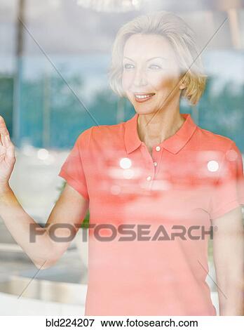 Stock Photo - Caucasian woman looking out window. Fotosearch