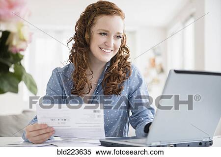 Caucasian woman paying bills using laptop View Large Photo Image Stock Photography - Caucasian woman paying bills using laptop. Fotosearch