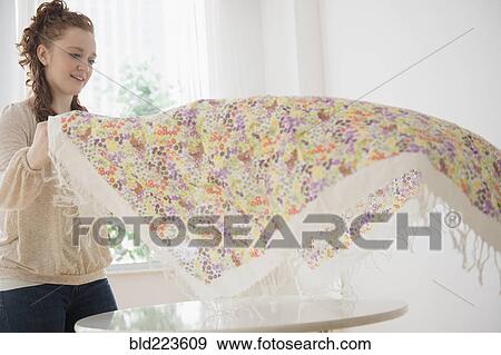 Caucasian woman placing tablecloth on table View Large Photo Image Stock Photo - Caucasian woman placing tablecloth on table. Fotosearch