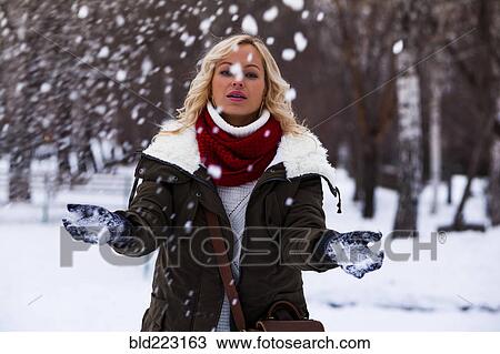 Stock Image - Caucasian woman playing in snow. Fotosearch