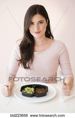 Stock Photograph - Caucasian woman preparing to eat TV dinner. Fotosearch