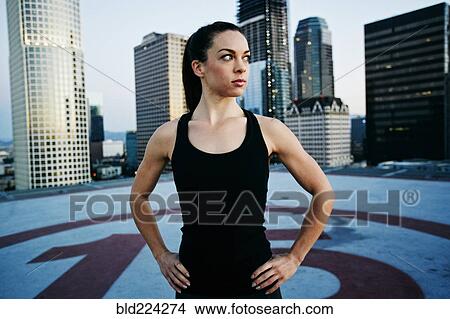 Picture - Caucasian woman resting on urban rooftop. Fotosearch