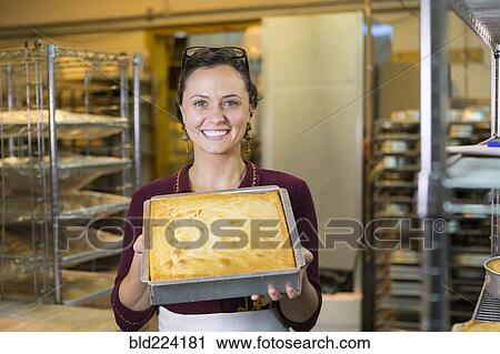 Caucasian woman showing cake in bakery pan View Large Photo Image Stock Image - Caucasian woman showing cake in bakery pan. Fotosearch