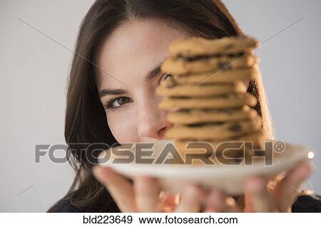 Caucasian woman showing pile of cookies on plate View Large Photo Image Stock Photo - Caucasian woman showing pile of cookies on plate. Fotosearch