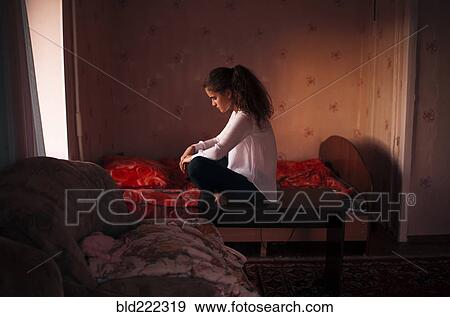 Stock Photo - Caucasian woman sitting in bedroom. Fotosearch