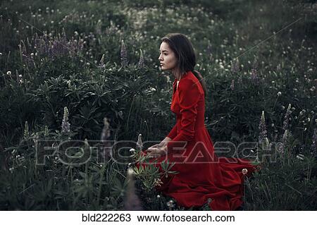 Stock Image - Caucasian woman sitting in field. Fotosearch