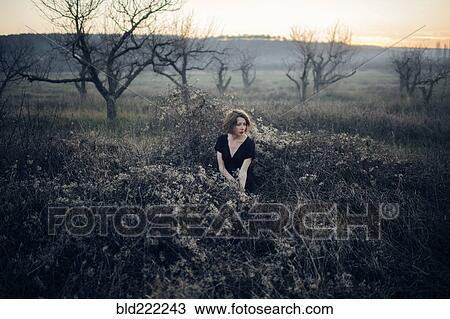 Caucasian woman sitting in remote field View Large Photo Image Stock Image - Caucasian woman sitting in remote field. Fotosearch