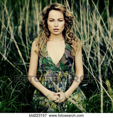 Caucasian woman sitting in tall grass View Large Photo Image Stock Photo - Caucasian woman sitting in tall grass. Fotosearch