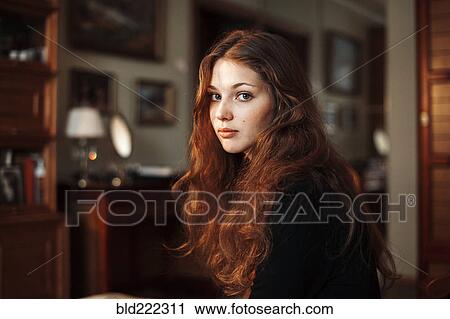 Stock Image - Caucasian woman sitting indoors. Fotosearch