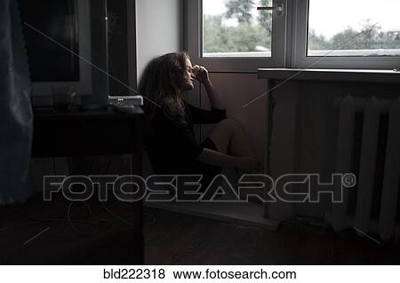 Stock Photo - Caucasian woman sitting near door. Fotosearch