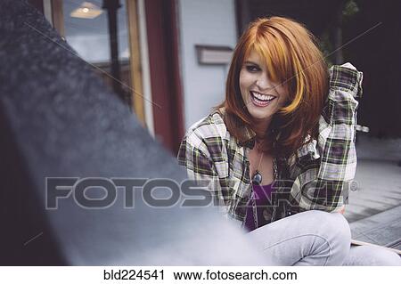 Stock Image - Caucasian woman sitting outdoors. Fotosearch