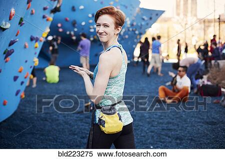 Stock Photography - Caucasian woman smiling at outdoor climbing wall. Fotosearch