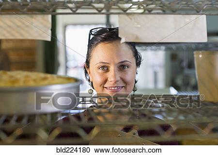 Caucasian woman smiling at shelf in bakery View Large Photo Image Stock Image - Caucasian woman smiling at shelf in bakery. Fotosearch