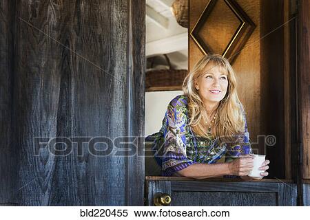 Stock Photography - Caucasian woman smiling in doorway. Fotosearch