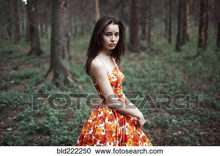 Stock Image - Caucasian woman standing in forest. Fotosearch