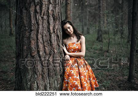 Stock Image - Caucasian woman standing in forest. Fotosearch