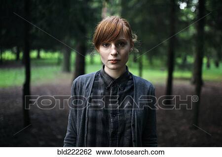 Stock Image - Caucasian woman standing in forest. Fotosearch
