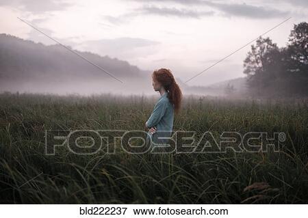 Stock Photo - Caucasian woman standing in remote field. Fotosearch