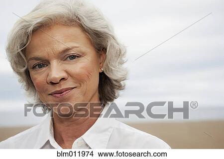 Picture - Caucasian woman standing on beach. Fotosearch