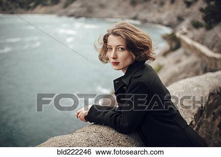 Caucasian woman standing on cliff over coastline View Large Photo Image Stock Photograph - Caucasian woman standing on cliff over coastline. Fotosearch