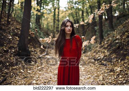 Stock Photo - Caucasian woman standing on forest path. Fotosearch