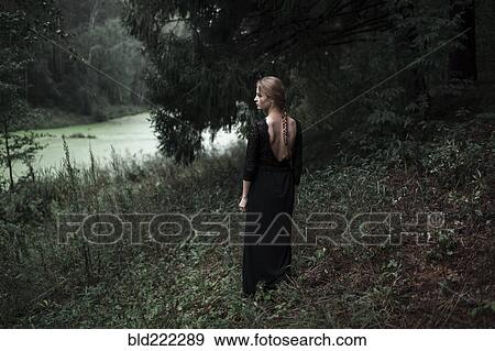 Stock Photo - Caucasian woman standing on forest hillside. Fotosearch