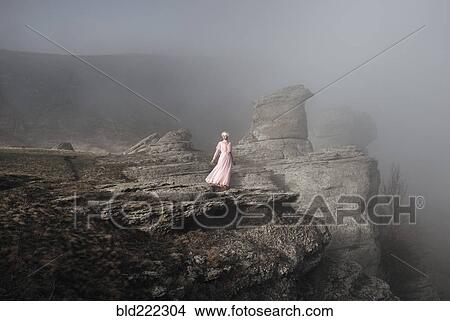 Caucasian woman standing on misty rock formation View Large Photo Image Picture - Caucasian woman standing on misty rock formation. Fotosearch
