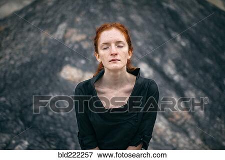 Stock Photo - Caucasian woman standing on rock formation. Fotosearch